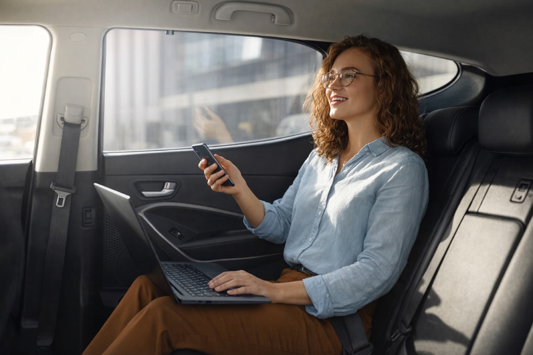 A passenger using a smartphone in a taxi